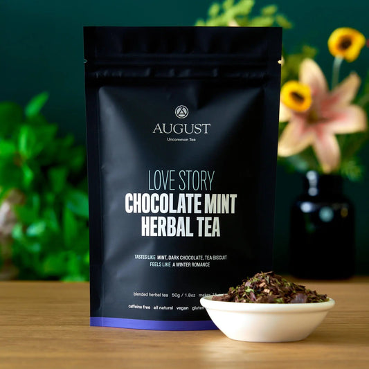Love Story chocolate mint herbal tea bag with mint leaves in a bowl, caffeine free and vegan, perfect for winter romance.