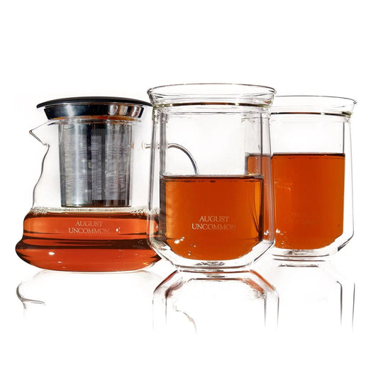 starter glass tea set featuring a glass teapot and double-walled tasting glasses with brewed tea.
