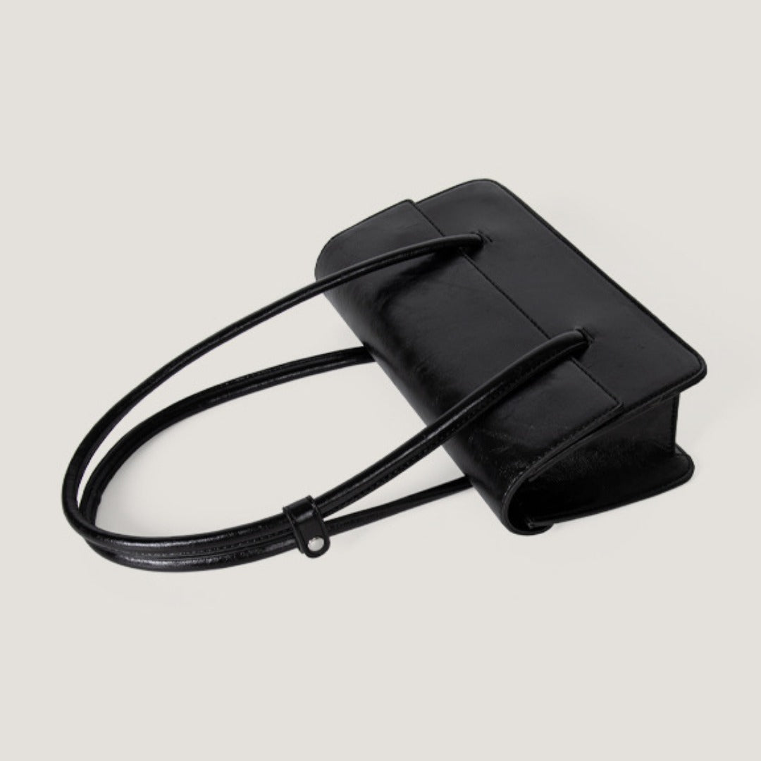 Black oil wax leather shoulder tote bag with long straps, showcasing a stylish and practical design.