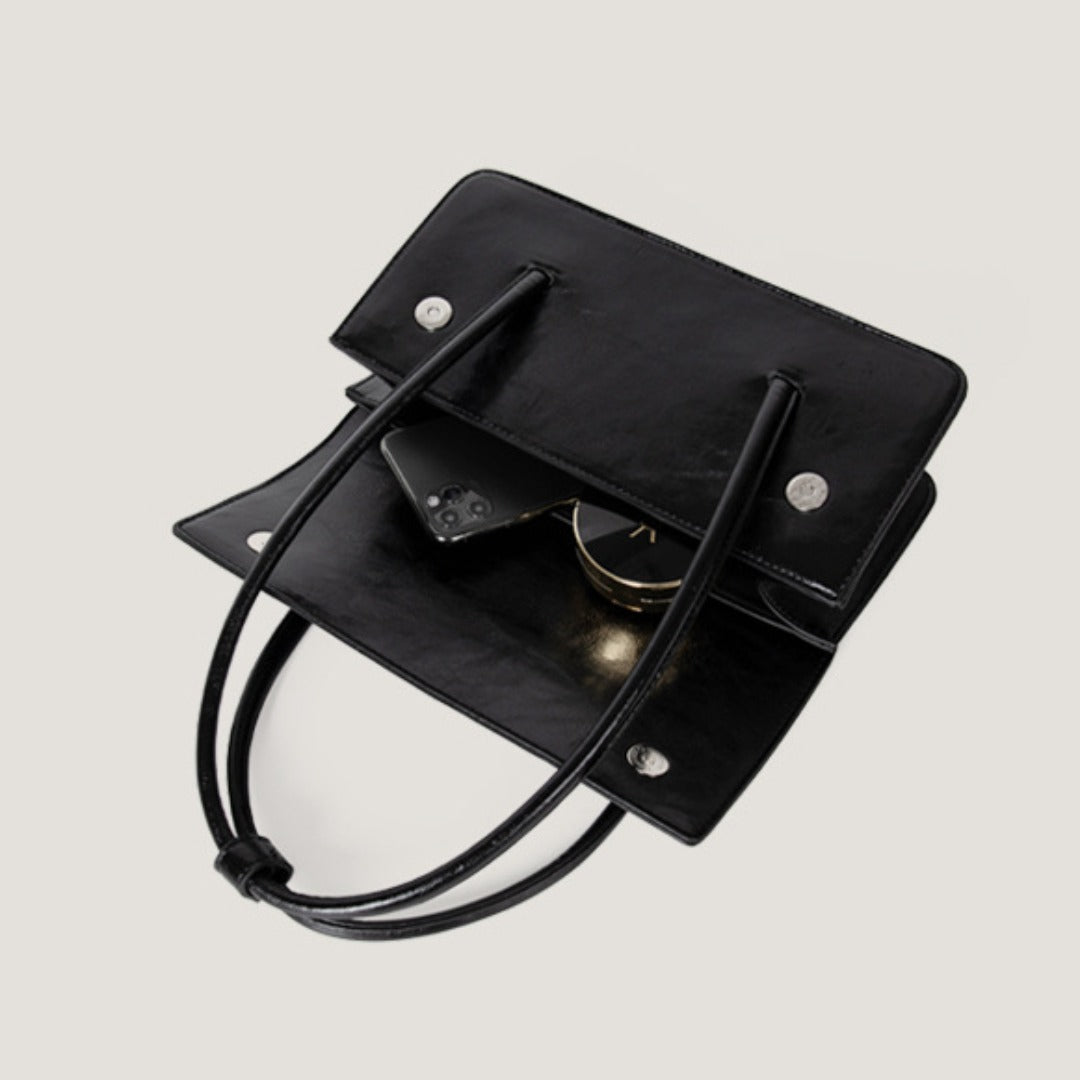 Interior view of an oil wax leather shoulder tote bag showing phone and accessories.