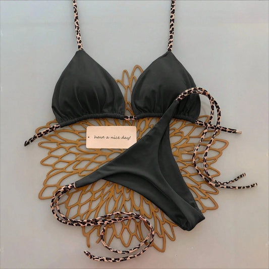 High-end women's bikini swimsuit in black with leopard print accents for a trendy beach look.