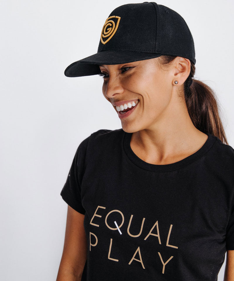 Woman smiling while wearing a G5 Flat Billed Snap Back Hat and an Equal Play t-shirt.