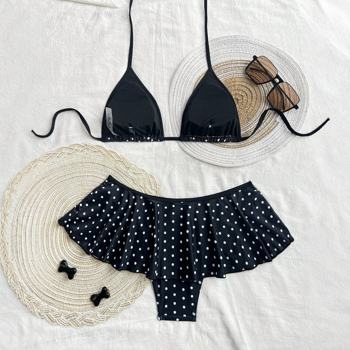 Women's black polka dot bikini set on a textured background, showcasing a stylish leopard print skirted bikini swimsuit design.