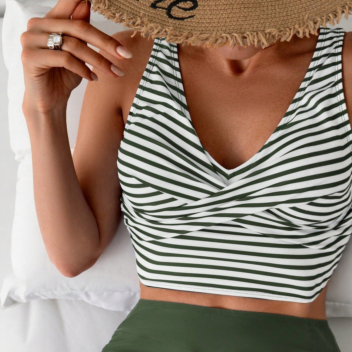 Close-up of a woman in a striped cross back tank top showcasing a quick dry two piece bikini swimsuit.