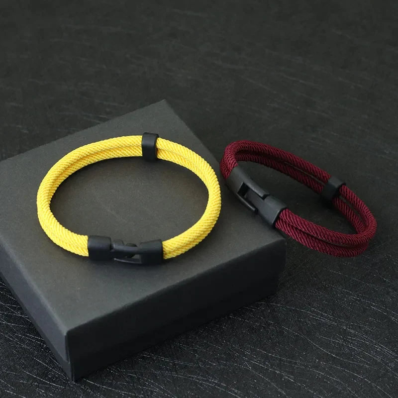 Men's double layer rope bracelet in yellow and maroon, showcased on a black jewelry gift box.