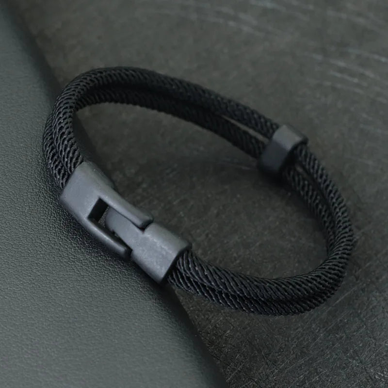 Black men's double layer rope bracelet featuring a modern matte black clasp design on a dark background.