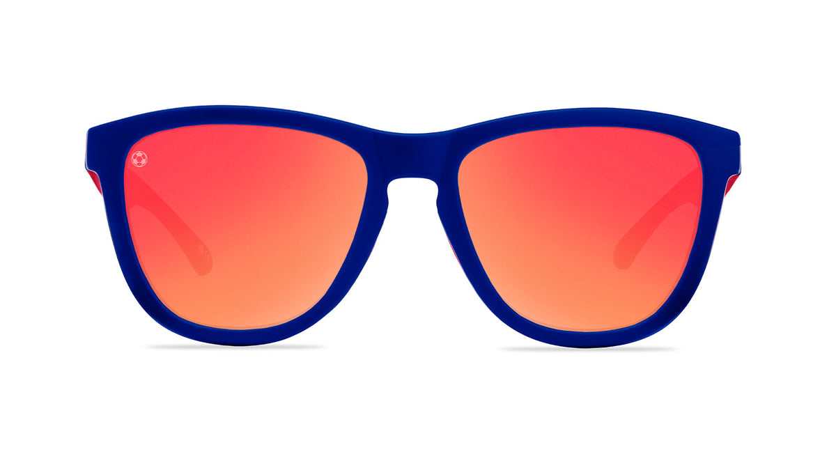 U.S. Soccer 2024 Knockaround Sunglasses featuring a stylish blue frame and gradient orange lenses.