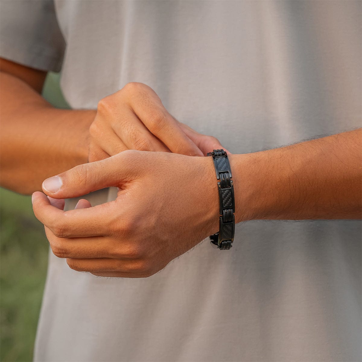 A man wearing the black carbon fiber magnetic bracelet on his wrist for style and magnetic therapy.