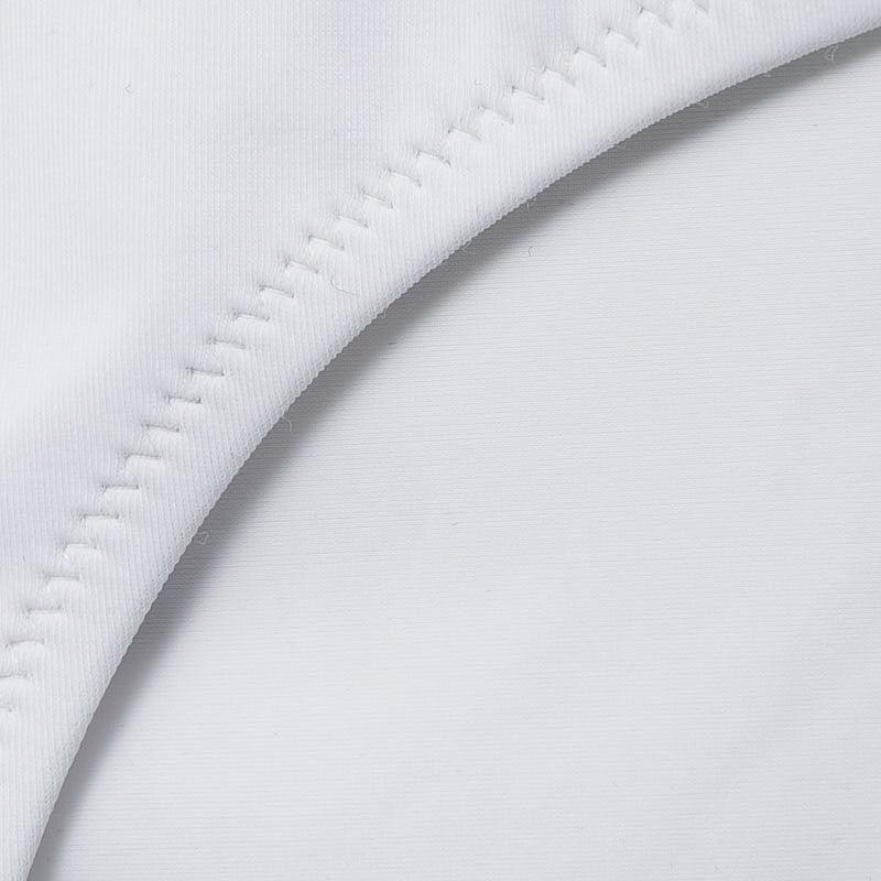 Close-up of the fabric seam on a white push up ruffled bikini set, showcasing smooth and durable material.