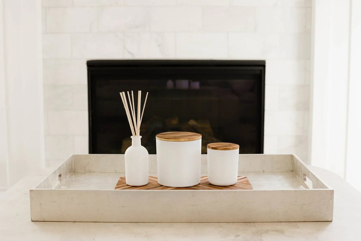White Sands scented candle and diffuser displayed on a decorative tray by a fireplace.